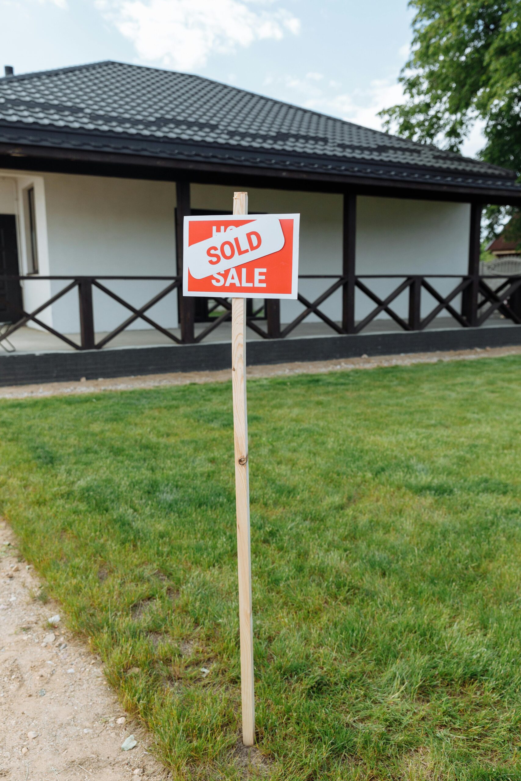 sold real estate sign in front yard representing how long it takes to sell a house in Oklahoma